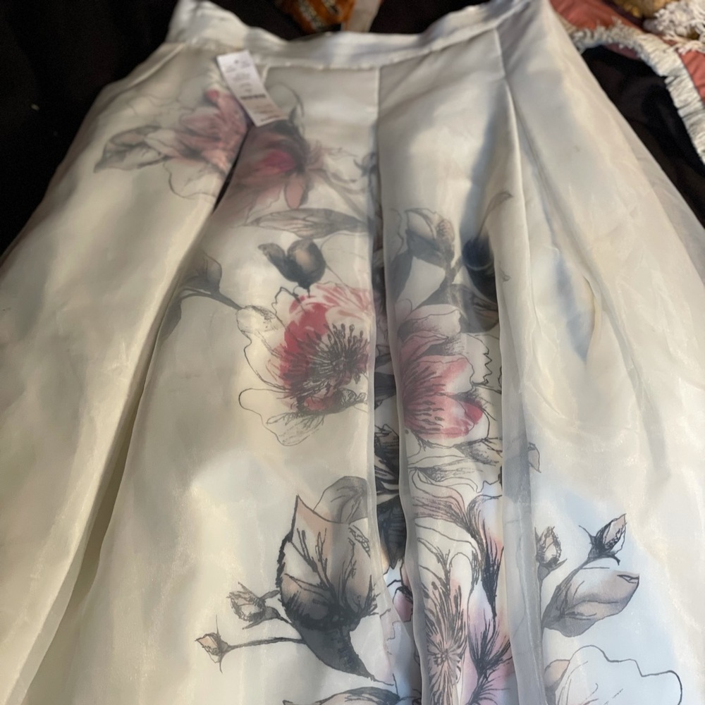 Below the knee, white floral skirt.